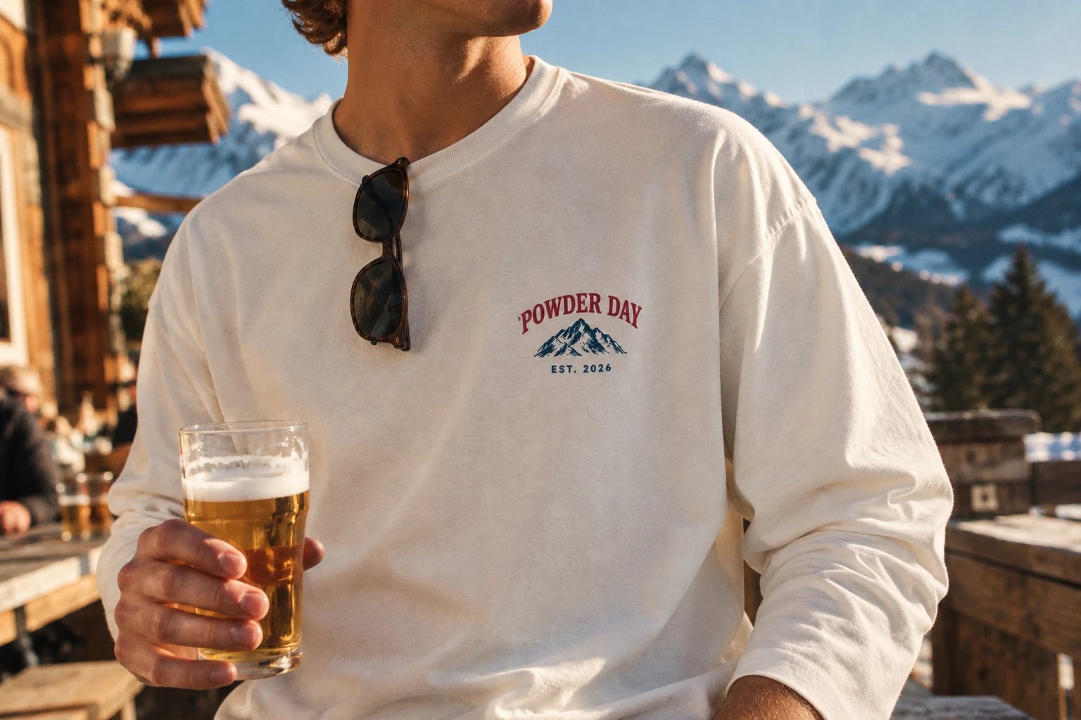 Close-up van het Mountain Club-borstlogo bij de après, met een biertje in de zon